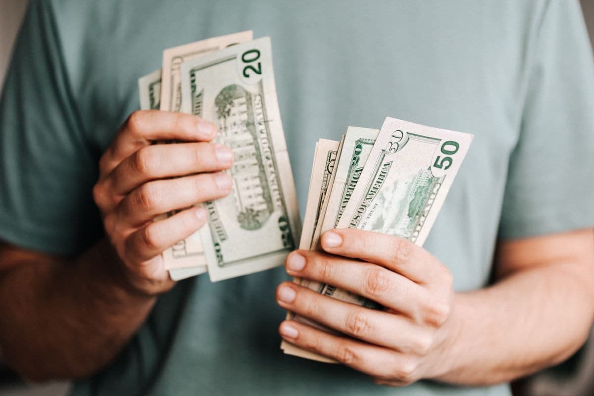 Hands holding a fan of banknotes